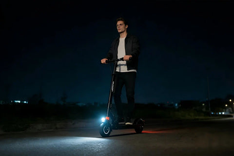 Rider wearing standard safety helmet riding JOYOR e-scooter, fully equipped for legal night travel in Europe and America